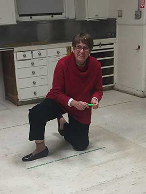 A woman measuring the San Jose Woman's Club's new floor