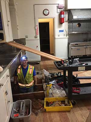 A worker removing the old floor of the San Jose Woman's Club kitchen